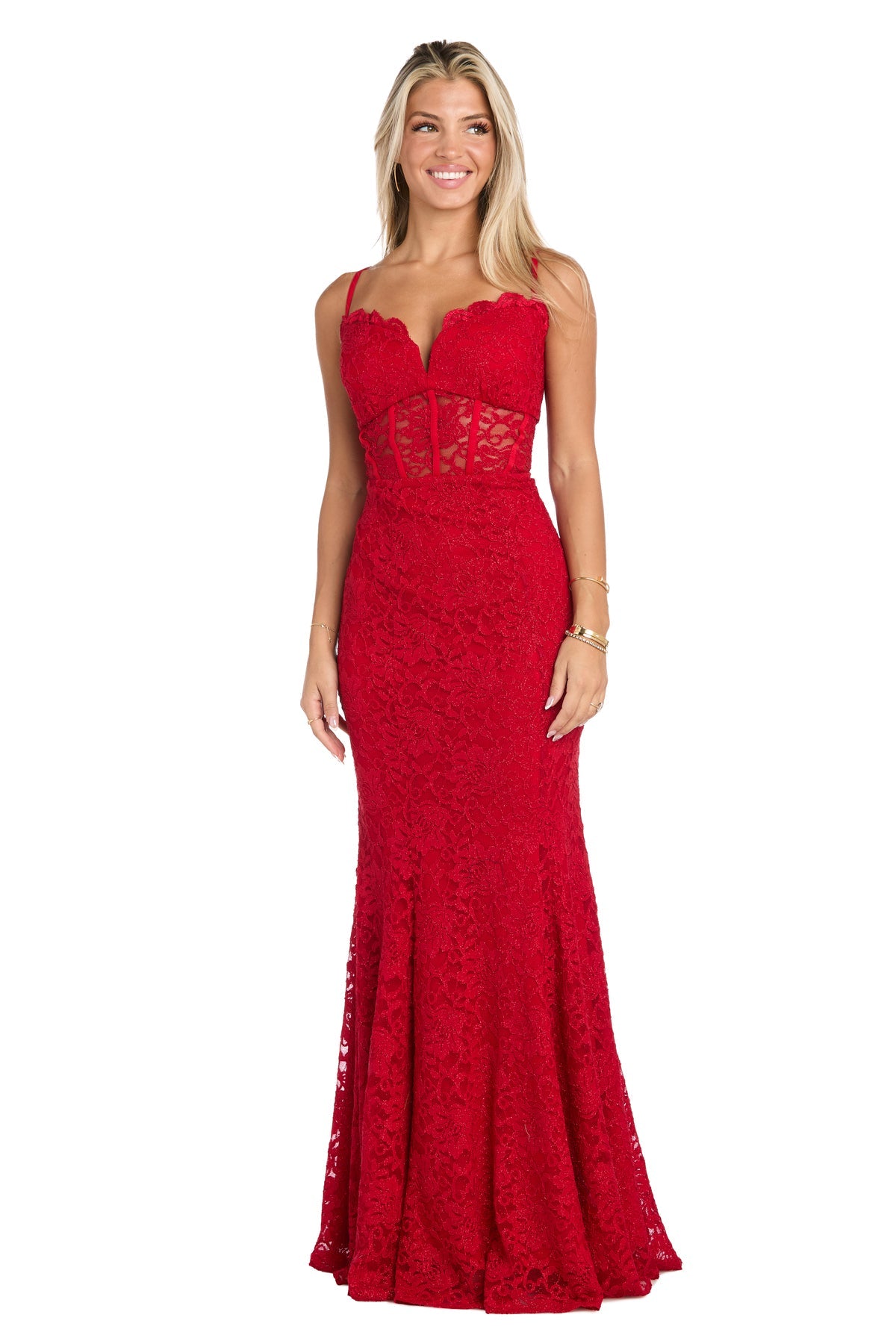 A woman in the Morgan 19069 Long Red Lace Prom Dress, featuring thin straps and a semi-sheer fitted bodice, stands against a white background.